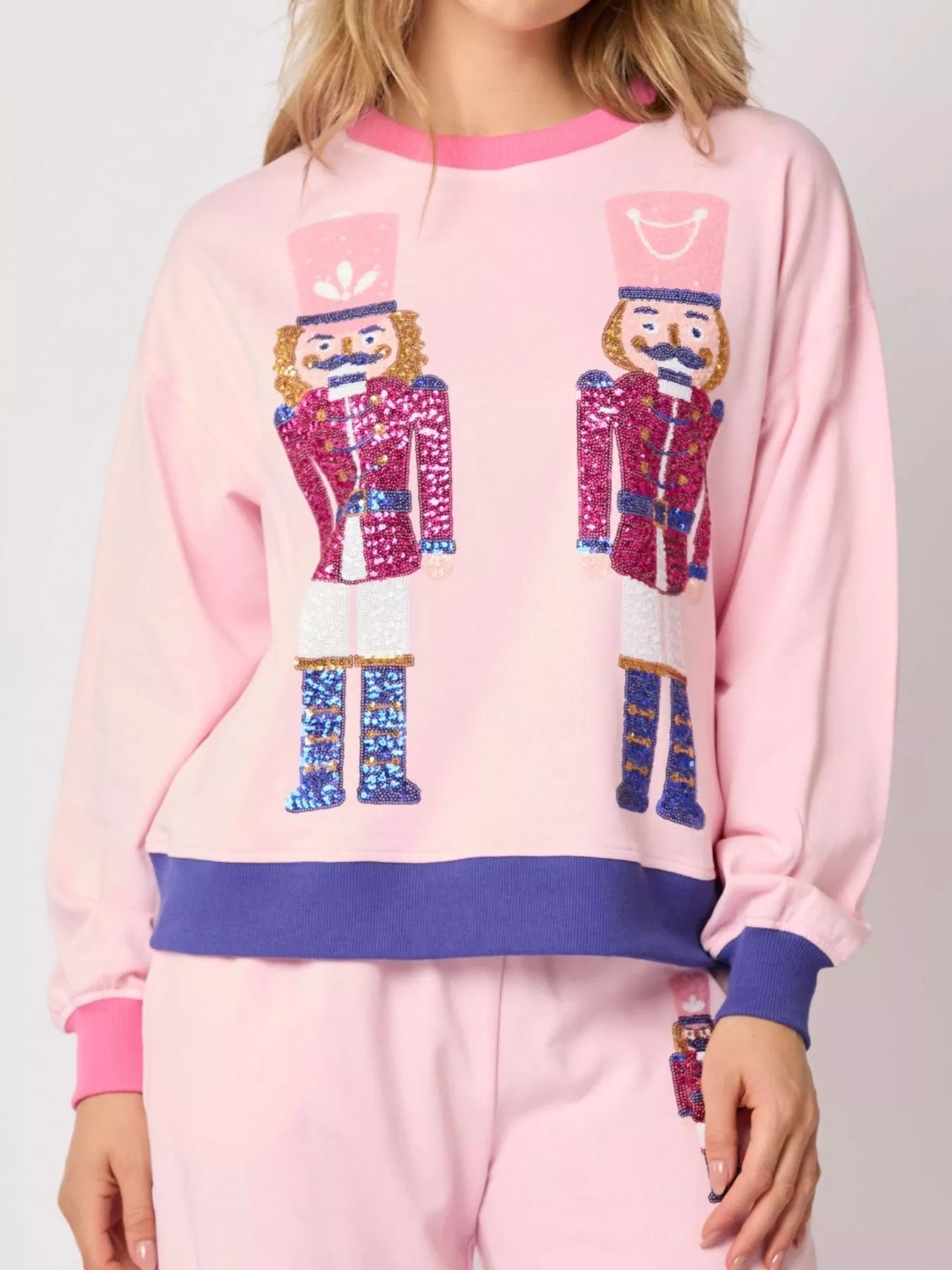 Pink pajama set with nutcracker design on a plain background