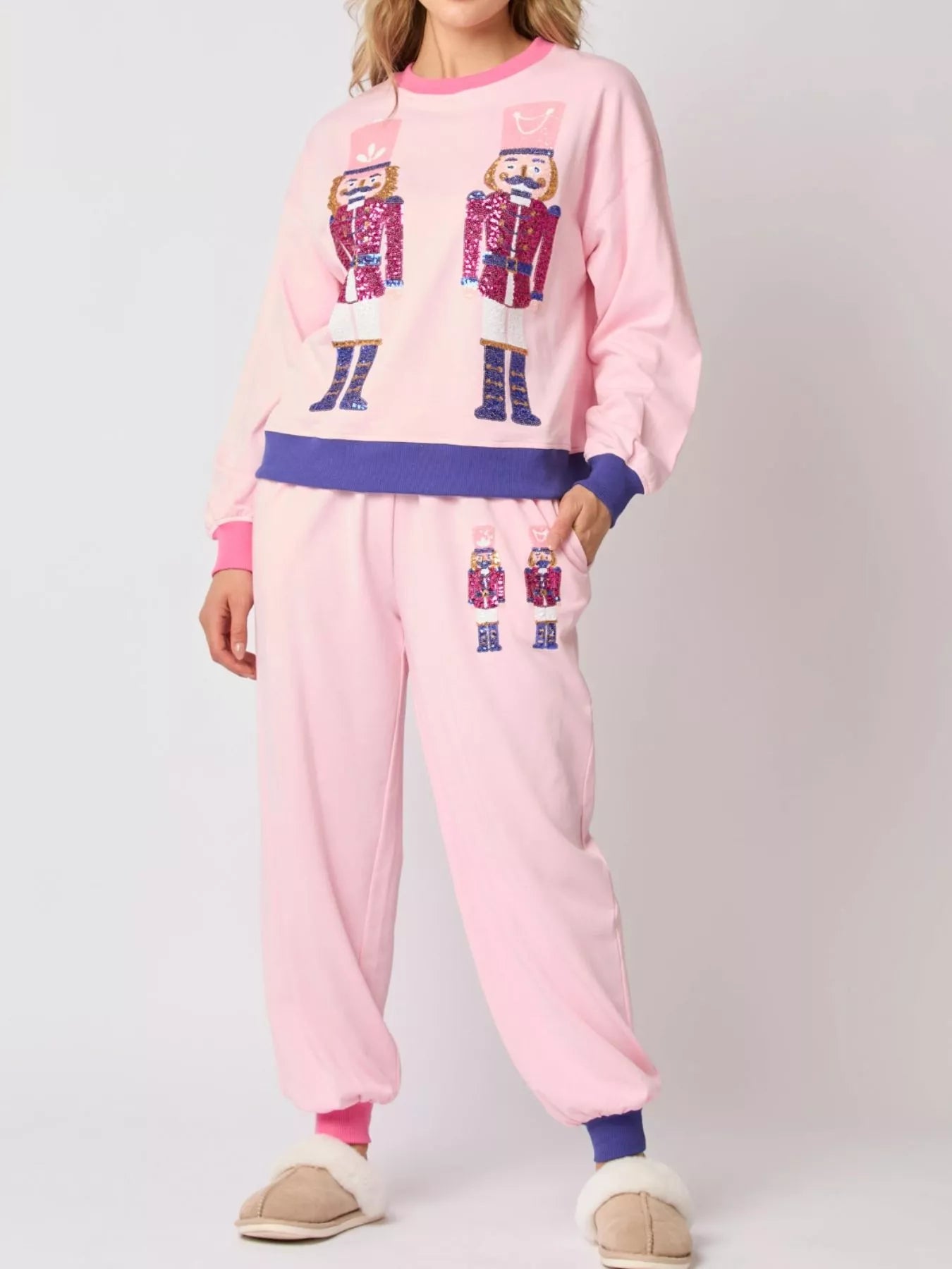 Person wearing pink pajama set with robot design on a plain background