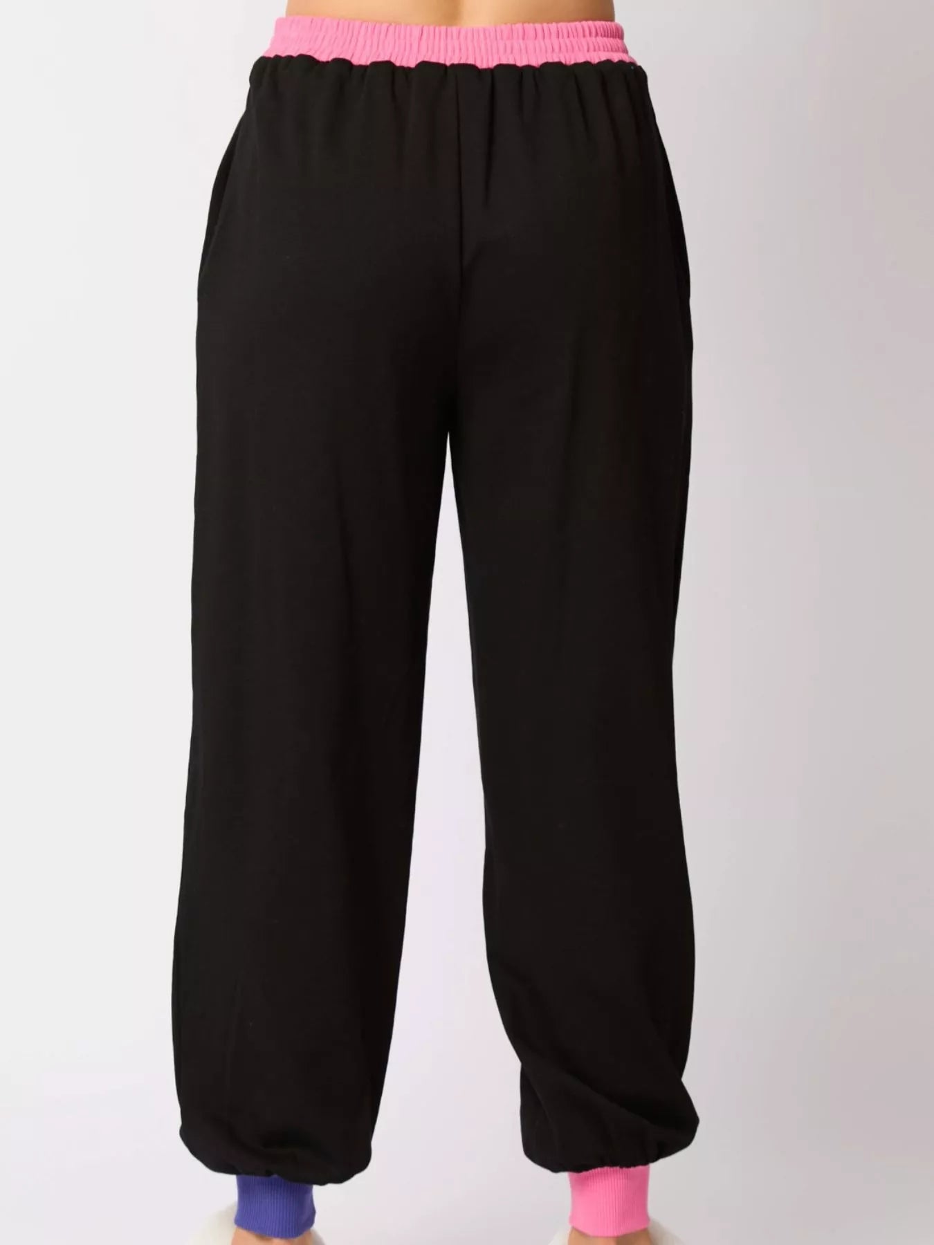 Black sweatpants with pink waistband and cuffs on a white background