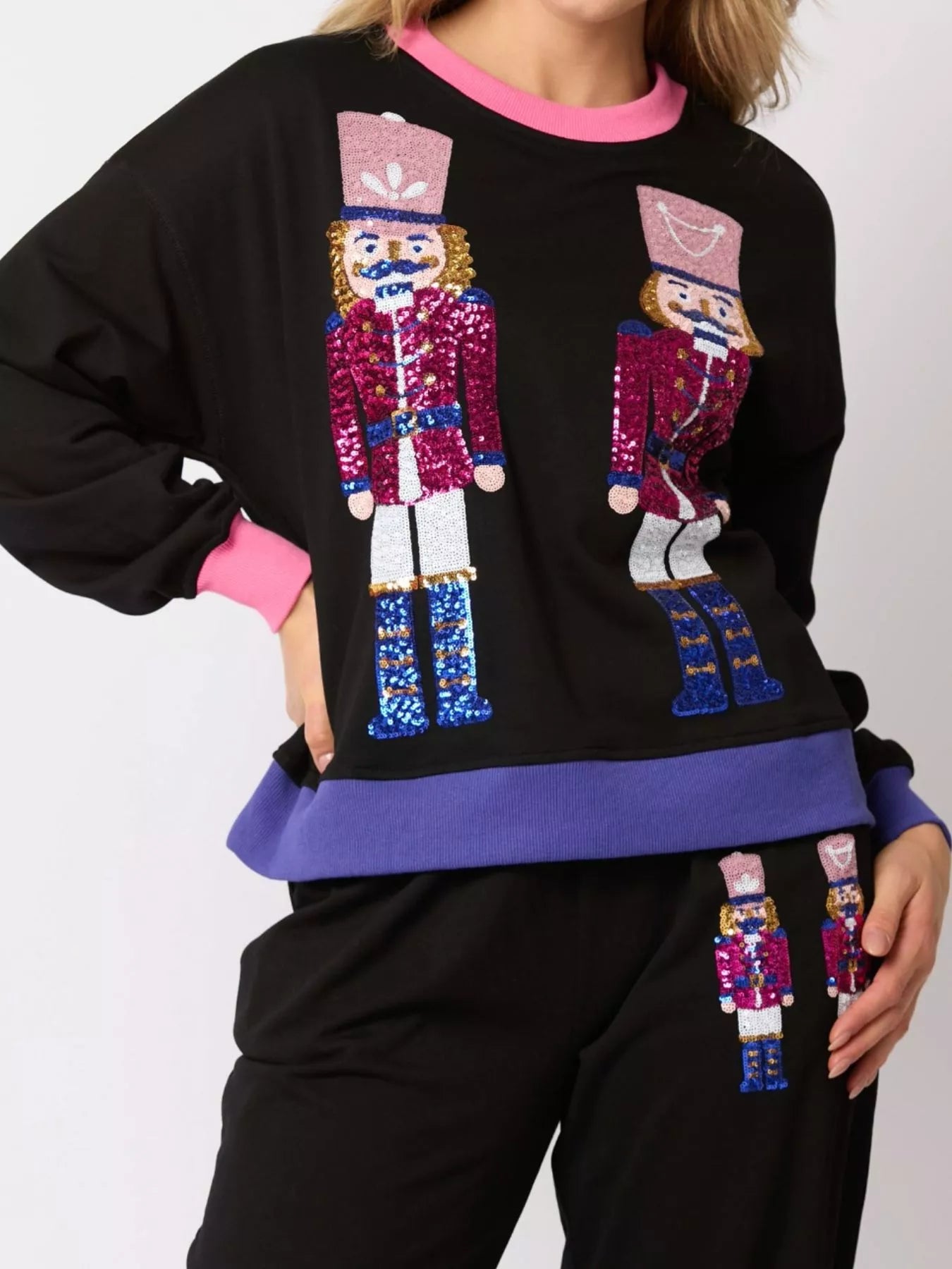 Black sweatshirt with sequin nutcracker design on a white background
