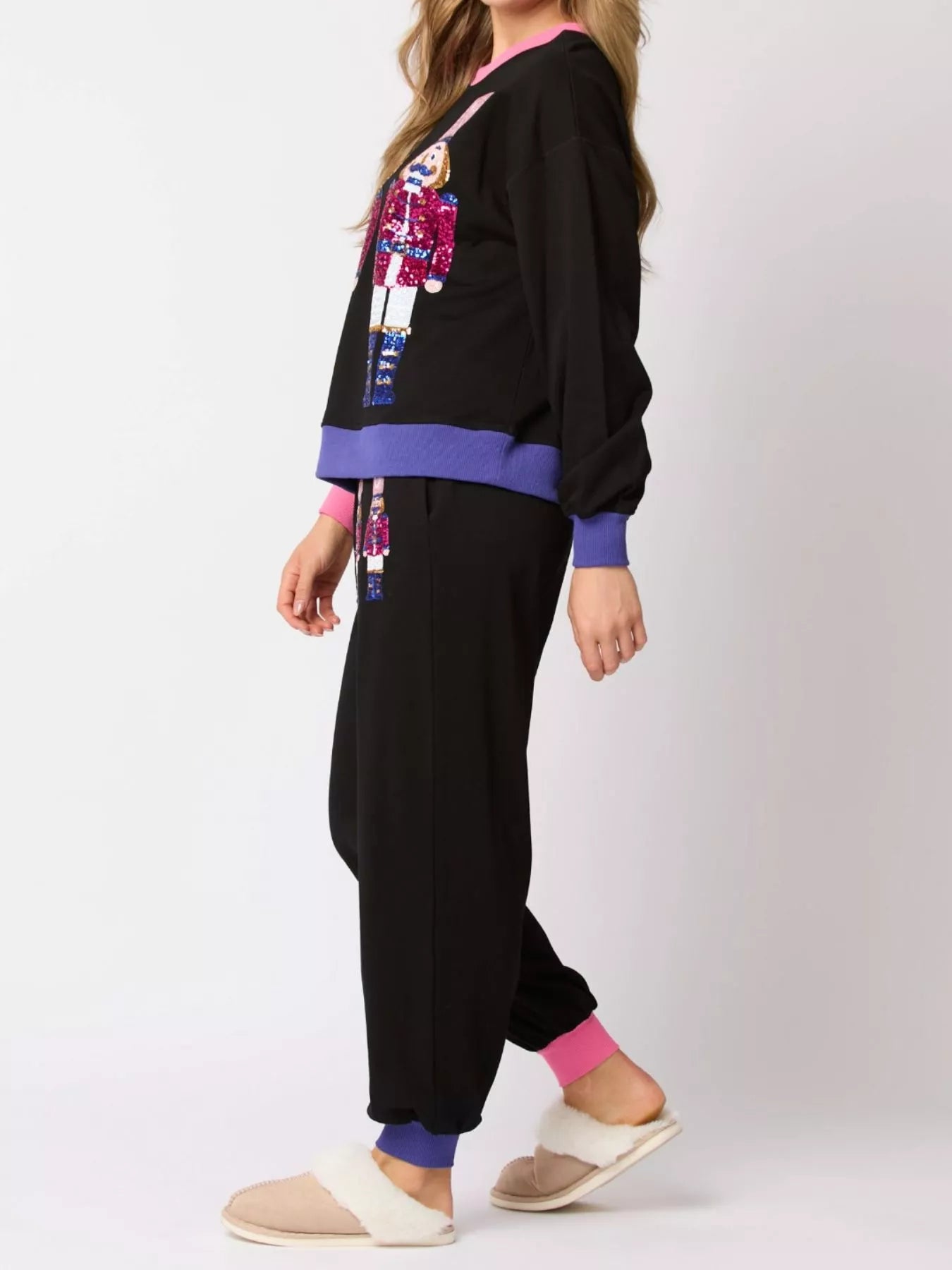 Person wearing a black outfit with colorful accents on a white background