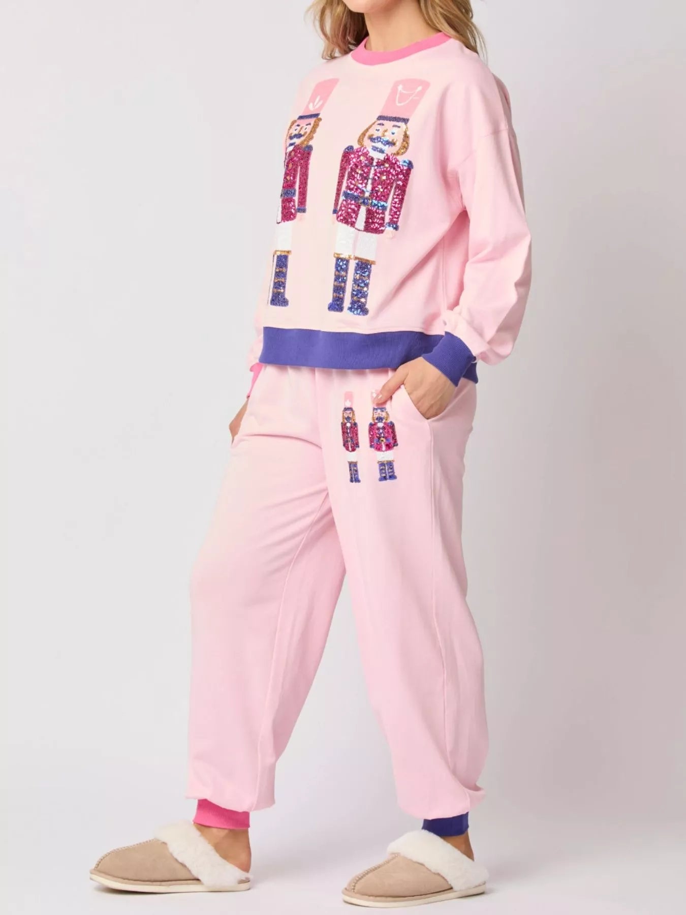 Person wearing a pink pajama set with colorful text design on a white background