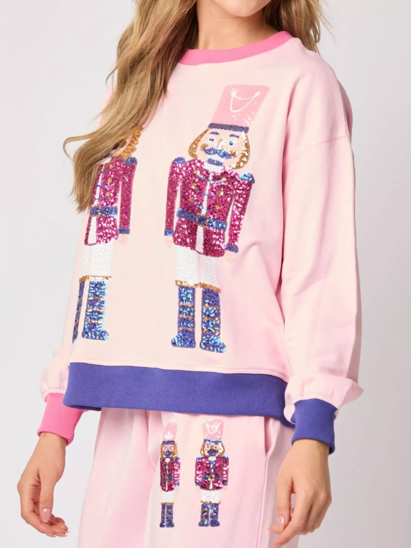 Pink pajama set with colorful nutcracker design on a plain background