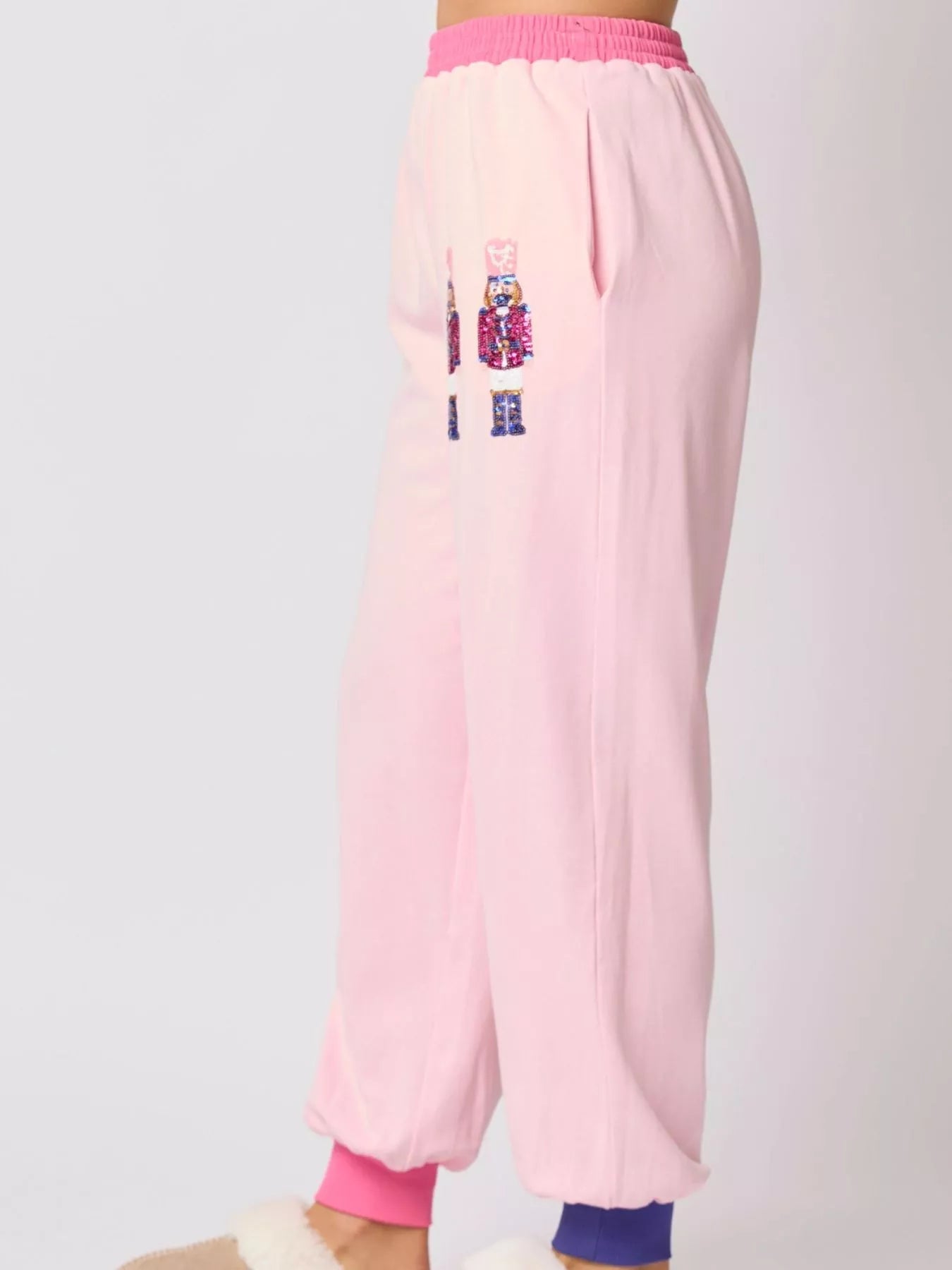 Pink Nutcracker sweatpants with colorful designs on a white background