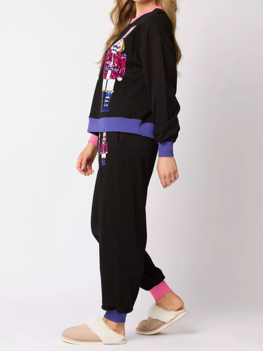 Person wearing a black outfit with colorful accents on a white background